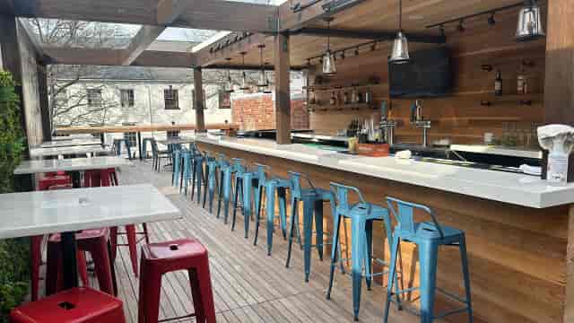Upstairs rooftop bar with high-top seating for corporate networking and private event receptions.