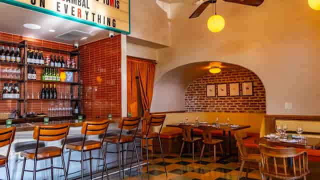 Networking reception venue at Palms Caribbean Fusion featuring vibrant booth and bar seating.
