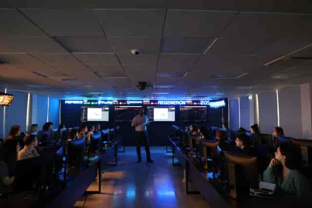High-tech lecture theatre with multi-screen displays for collaborative financial training events.