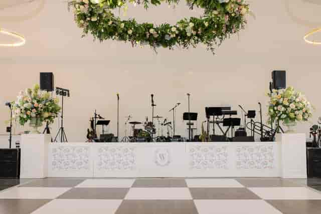 Wedding stage at Studio 101 with floral decor and checkered dance floor for luxury event hire.