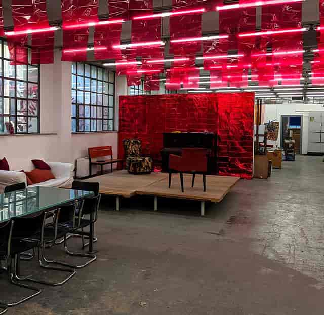 Industrial-chic event space with metallic red backdrop for experiential activations and galas.