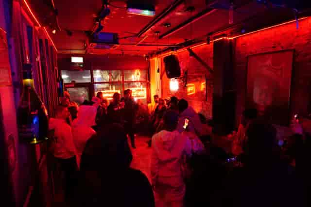 Industrial venue with red lighting for networking events and brand showcases.