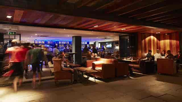 Modern breakout lounge with leather seating and bar for corporate conferences and networking events.
