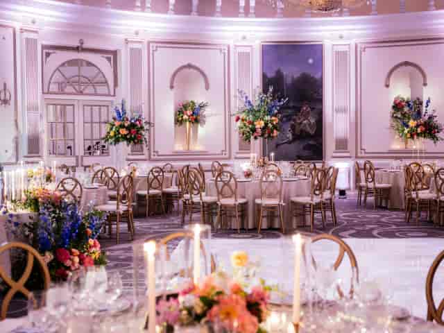 Elegant Hudson’s House ballroom gala setup with cross-back chairs and floral centerpieces.