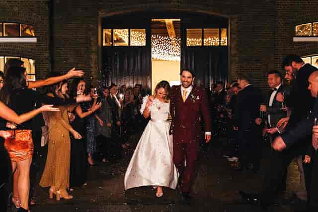 Rustic London Docklands warehouse wedding venue with atmospheric lighting for grand exit.