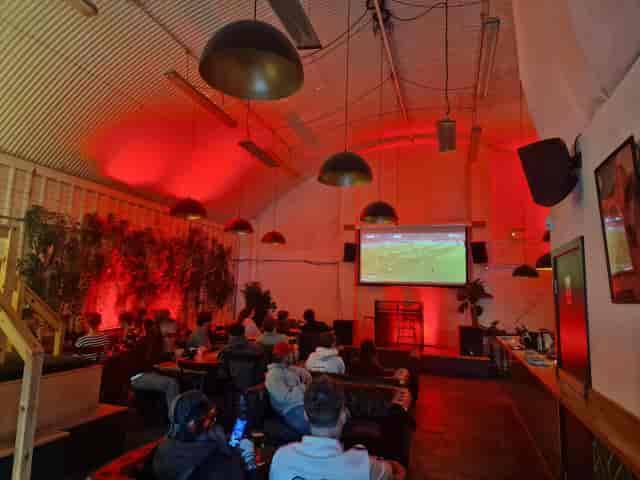 Industrial-chic Red Arch event venue with red lighting for lounge-style screenings.