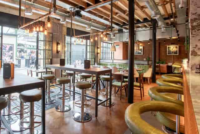 Industrial-chic terrace venue with high-top seating for networking and social events.