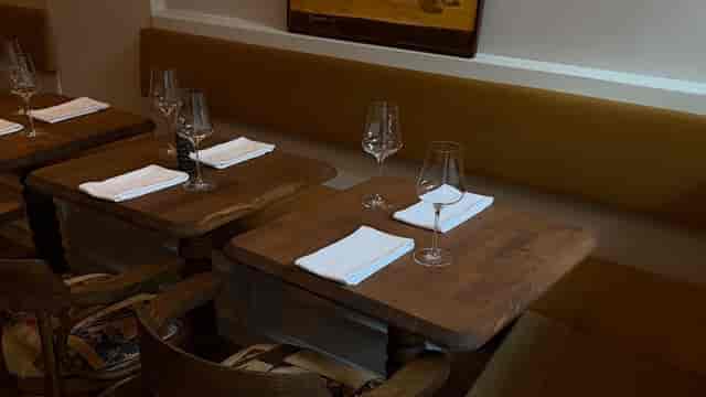 Modern restaurant venue with square tables and bench seating for private events and group dining.