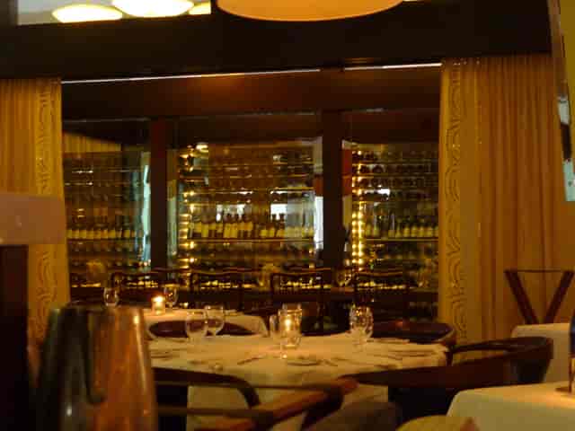 Grand Salon private dining room with backlit wine cellar for upscale corporate events.