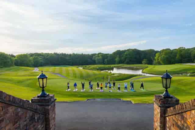 Wellness breakout session on David Lloyd Oxford outdoor terrace overlooking scenic golf course.