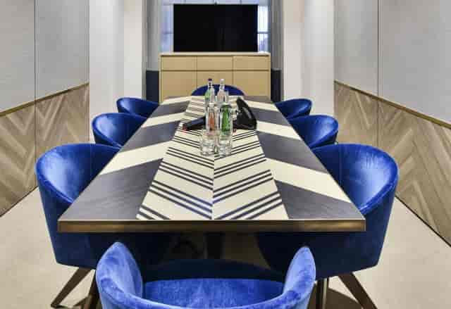 Executive boardroom with blue velvet chairs for private strategy meetings and corporate events.