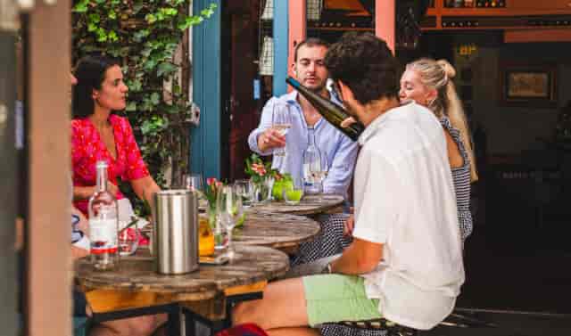 Outdoor corporate mixer at The Courtyard, Notting Hill featuring modular wooden tables for networking.