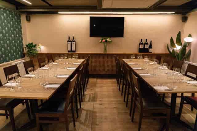 Private wine cellar dining room with long tables for corporate meetings and executive dinners.