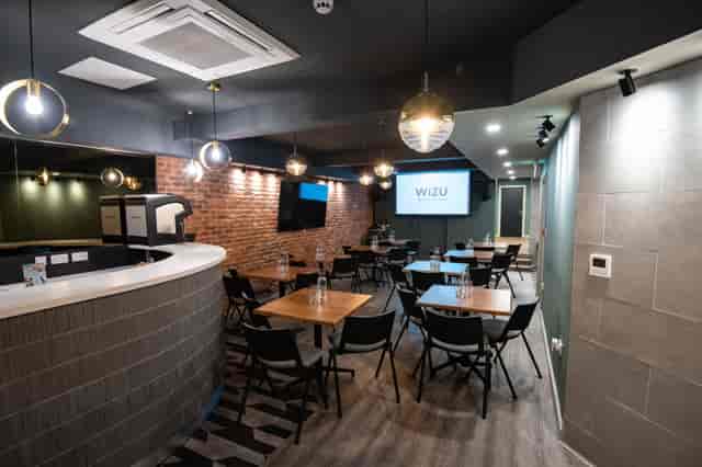 Industrial-chic event space with integrated bar for corporate workshops and networking mixers.