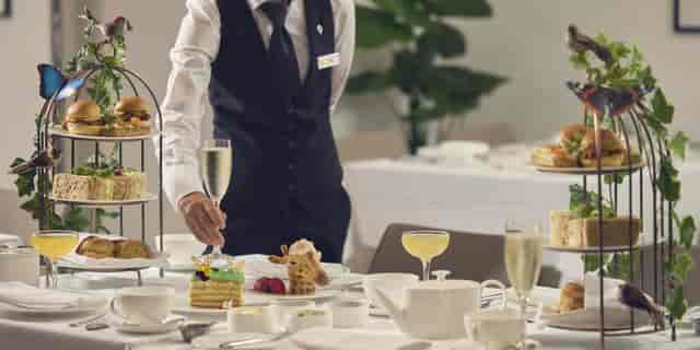 Professional afternoon tea service with sparkling wine at Millennium Hotel Belgravia Suite.