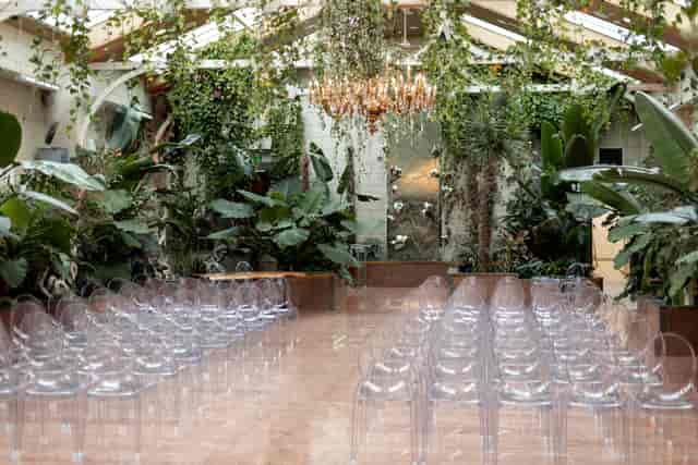 The Garden Room wedding ceremony space with crystal chandelier and modern greenery decor.