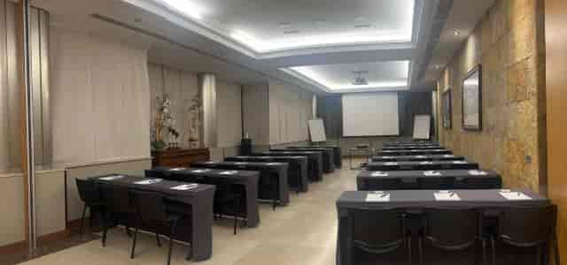 Classroom-style North Room at Hotel Villamadrid with AV screen for corporate training and meetings.