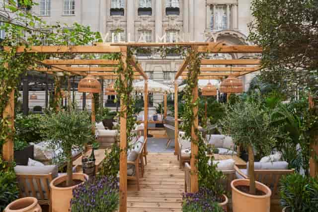 Mediterranean outdoor lounge with timber pergola for luxury brand activations and networking.