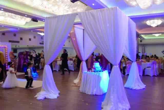 Crystal Suite wedding cake station with elegant drapery in Kervan Banqueting ballroom.