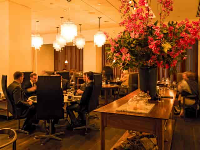 Lounge at Aquavit: High-end breakout space with floral centerpiece for executive board meetings.