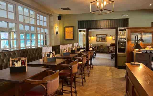 Conservatory pub-style breakout space with banquette seating for networking and business meetings.