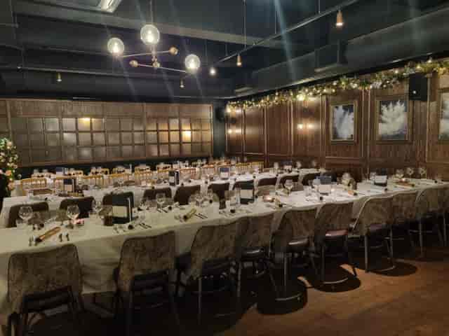 Banquet-style private event venue with long wooden tables for formal dinners.