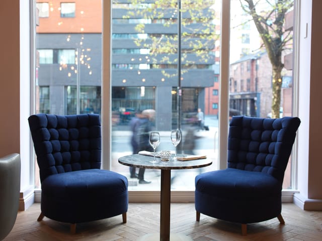 Cozy meeting space with plush blue chairs in ABode Manchester for networking events.