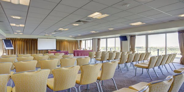 Park View Suite at Sandown Park: bright conference room with yellow chairs for events.