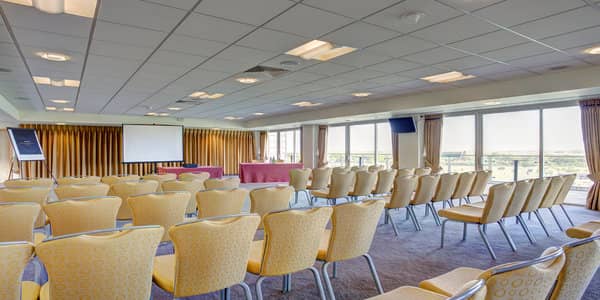 Park View Suite at Sandown Park: bright conference room with yellow chairs for events.