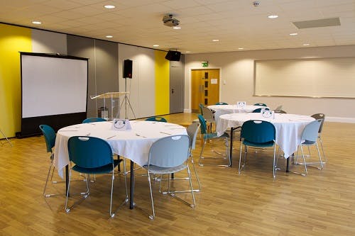 Liddell Hall meeting space with round tables, ideal for workshops and conferences.