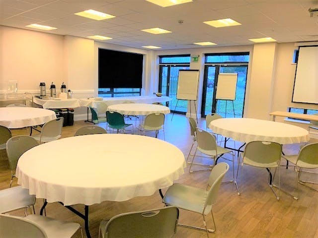 Muller Room at The LifeCentre, bright meeting space with round tables for events.