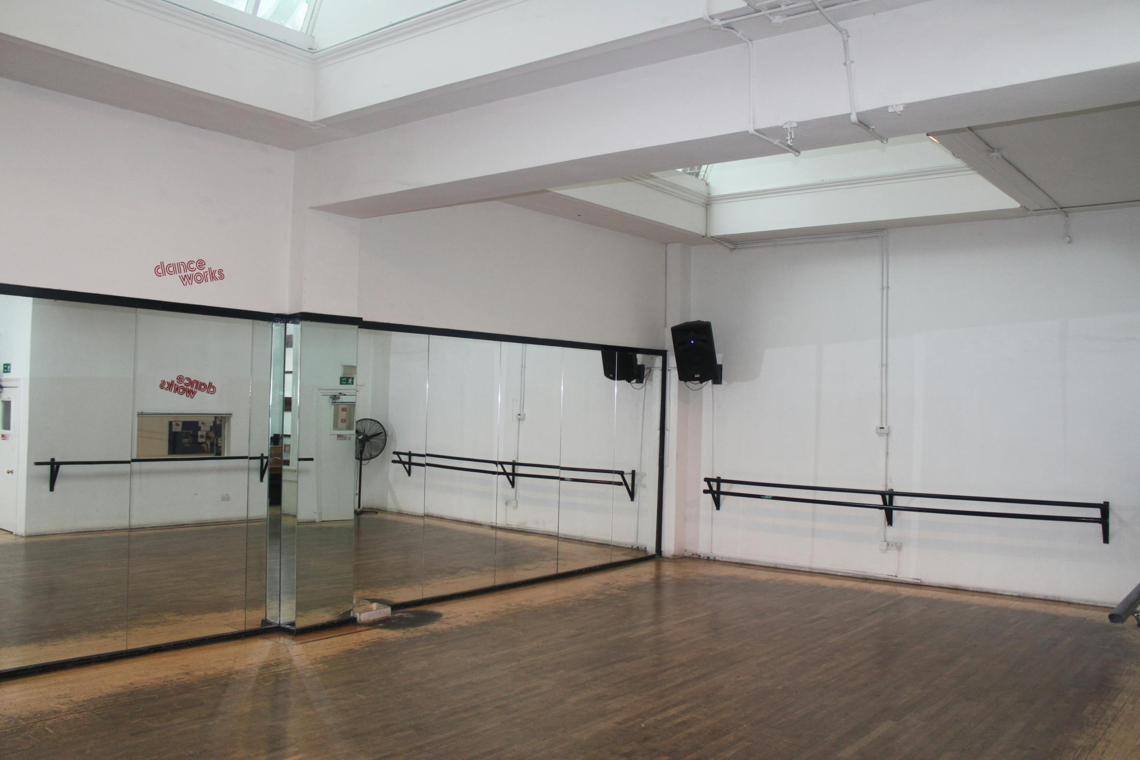 Versatile dance studio with large mirrors, ideal for workshops and fitness events.