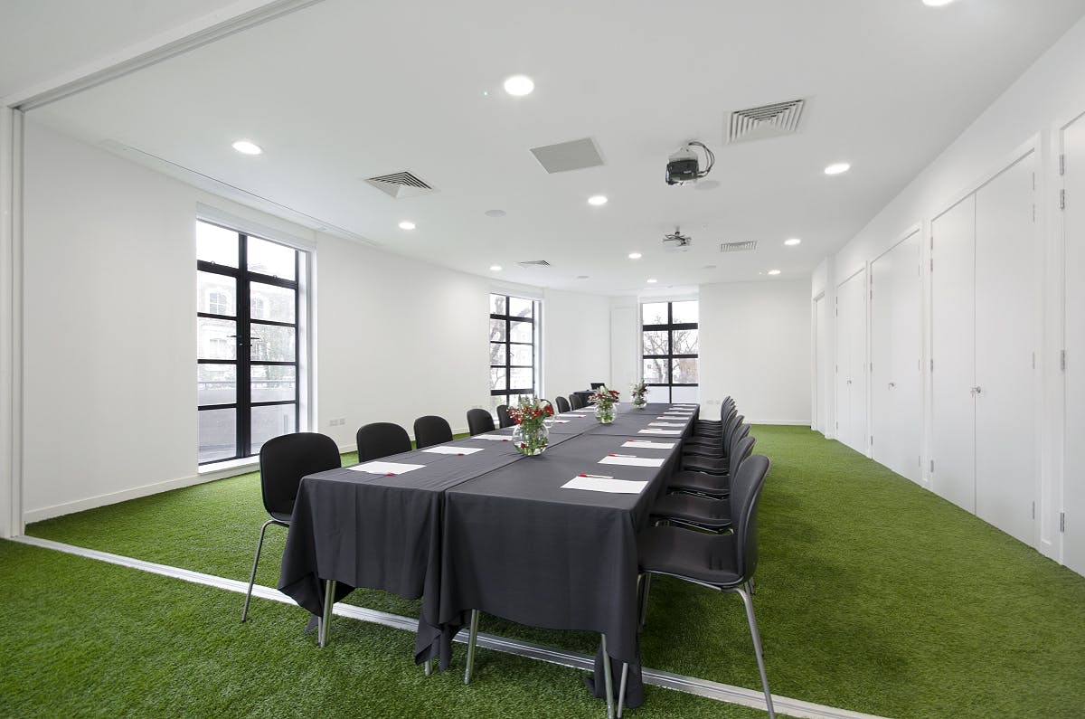 Modern conference room with artificial grass flooring for creative workshops.