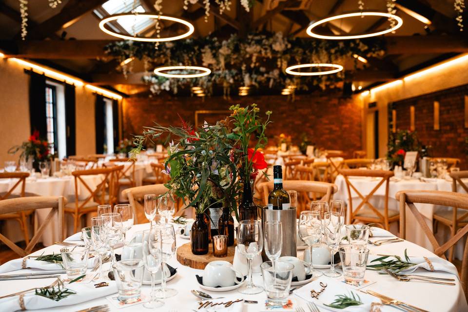 Rustic-chic Merchant Room banquet hall with halo pendant lighting for upscale wedding event venue. - Banner