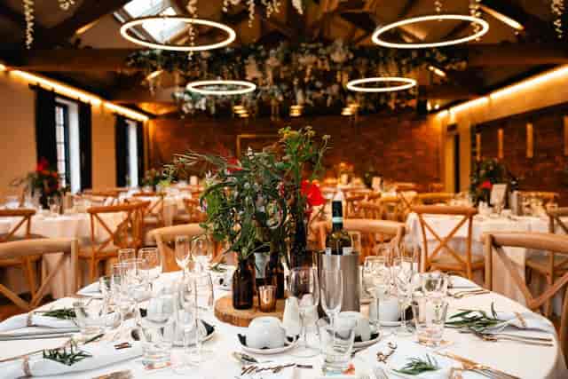 Rustic-chic Merchant Room banquet hall with halo pendant lighting for upscale wedding event venue.