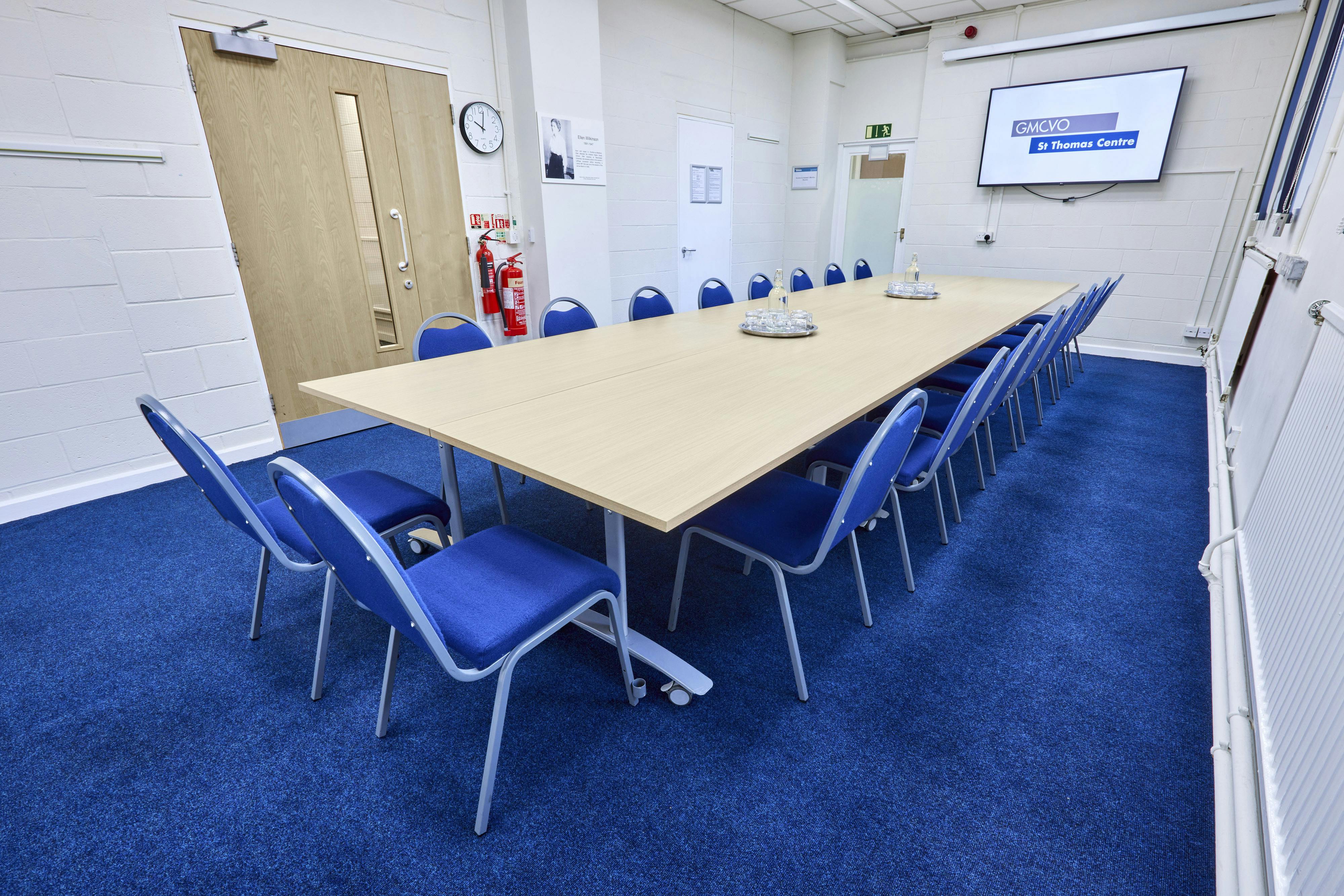 Wilkinson Room in St Thomas Centre: modern meeting space with blue chairs, ideal for conferences.