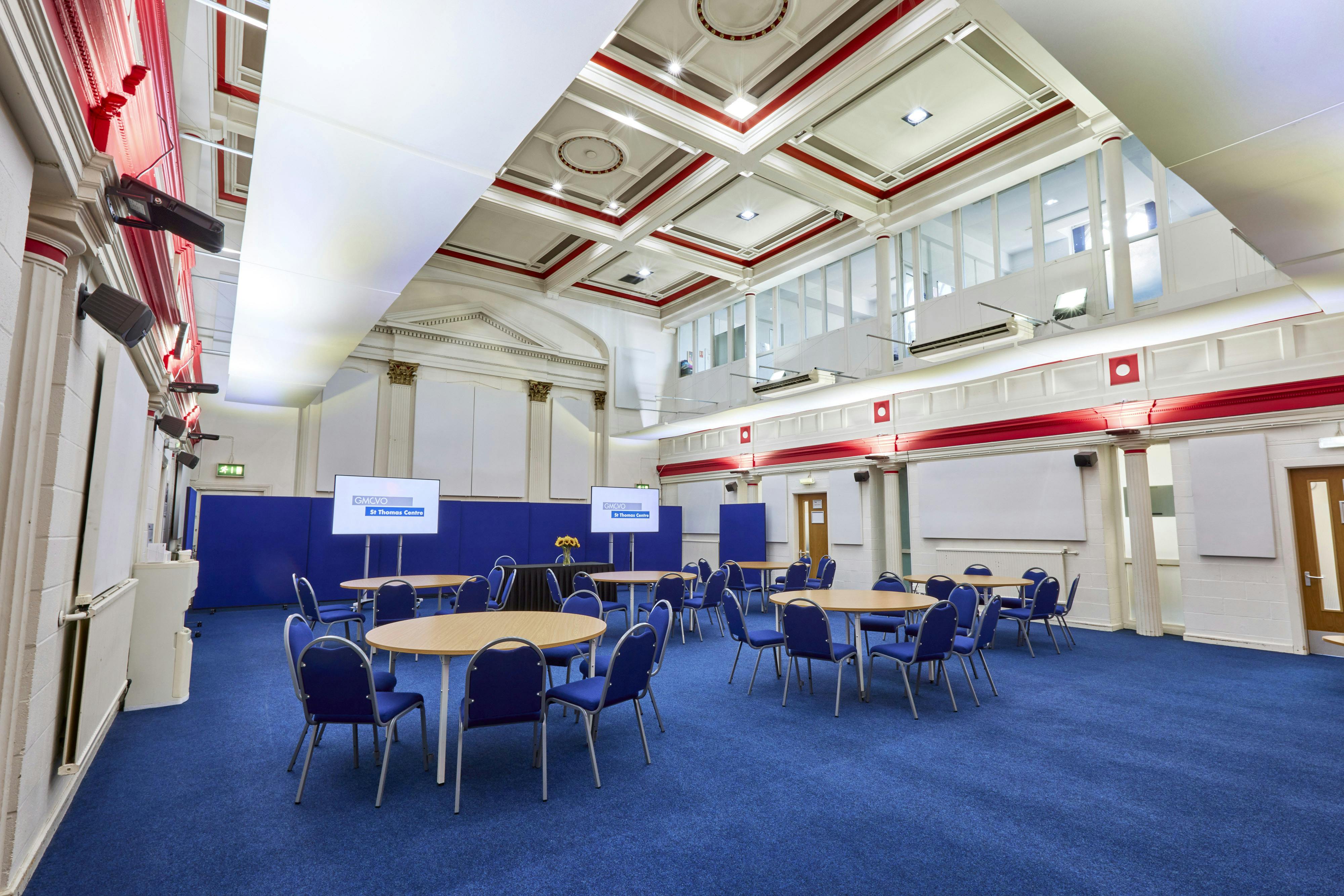 Spacious meeting room with round tables, ideal for workshops and networking events.