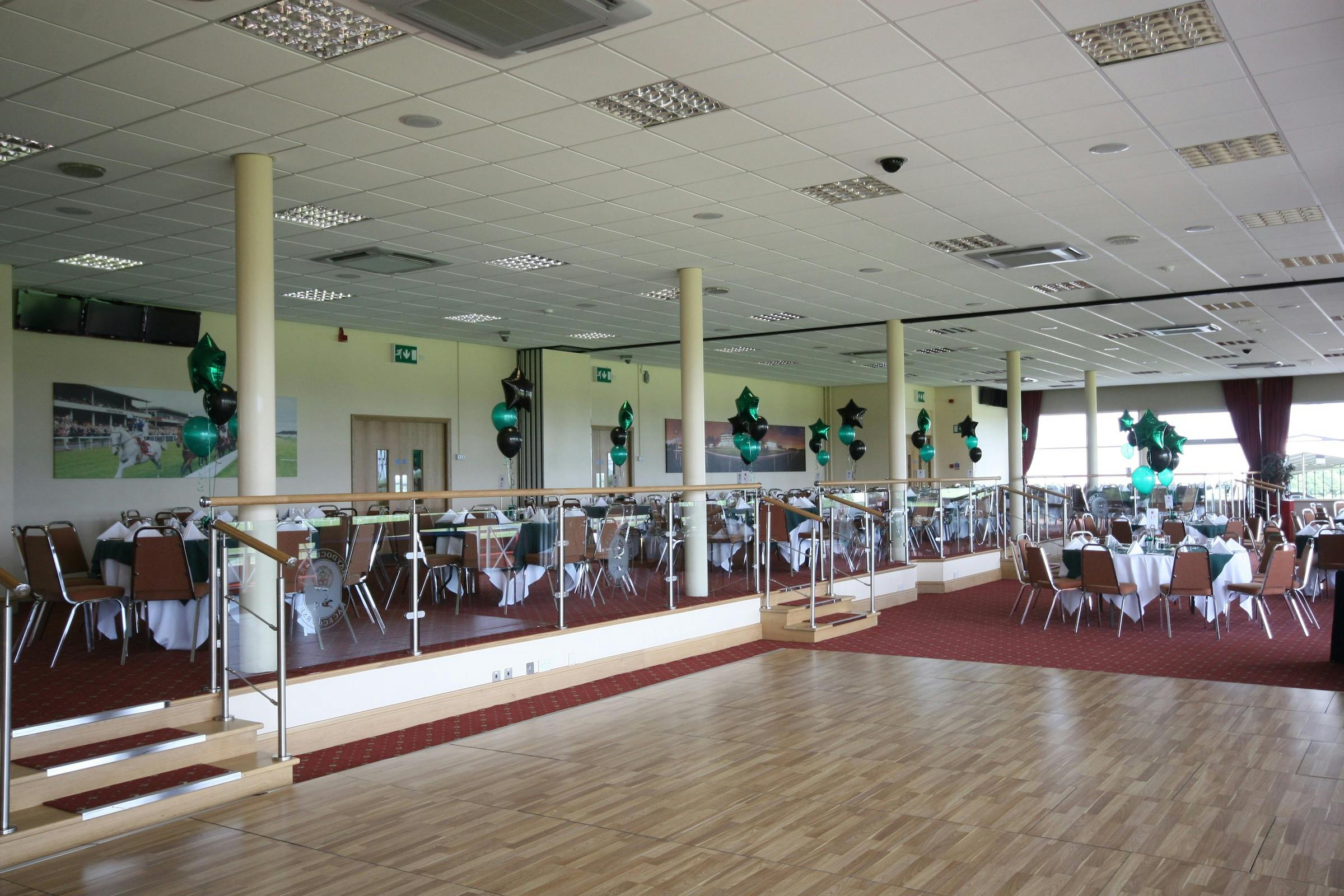 Spacious Park Suite venue at Haydock Park, set for formal events with elegant decor.