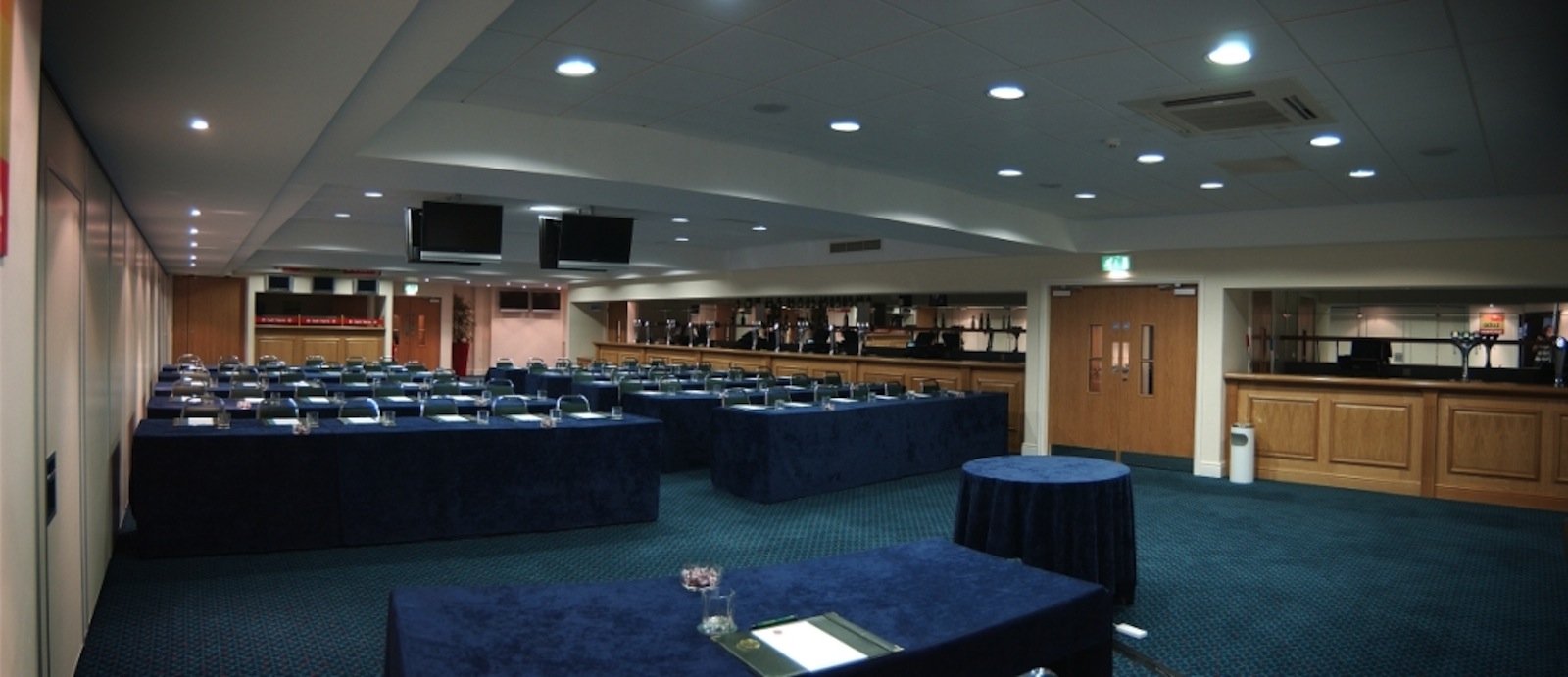 Horseshoe Suite at Haydock Park: conference room with blue tablecloths and screens. - Banner