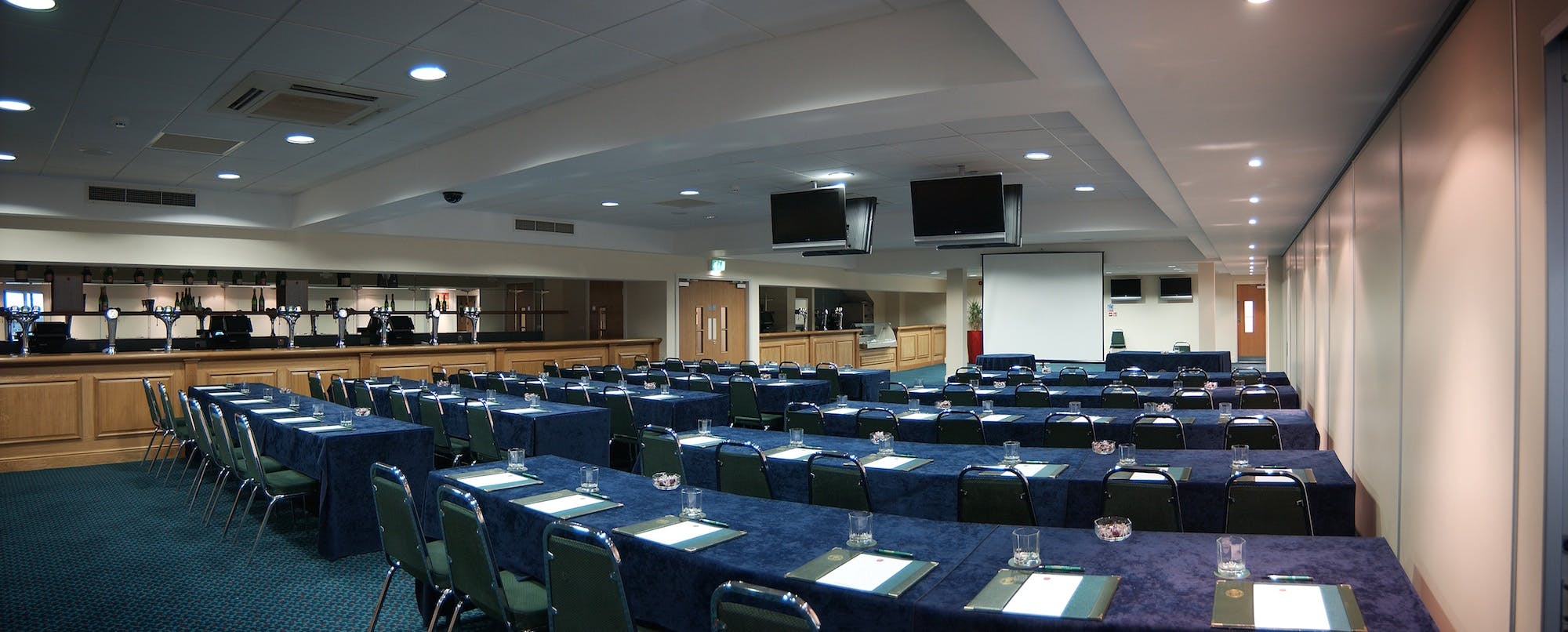 Horseshoe Suite at Haydock Park, conference setup with blue tablecloths and screens.