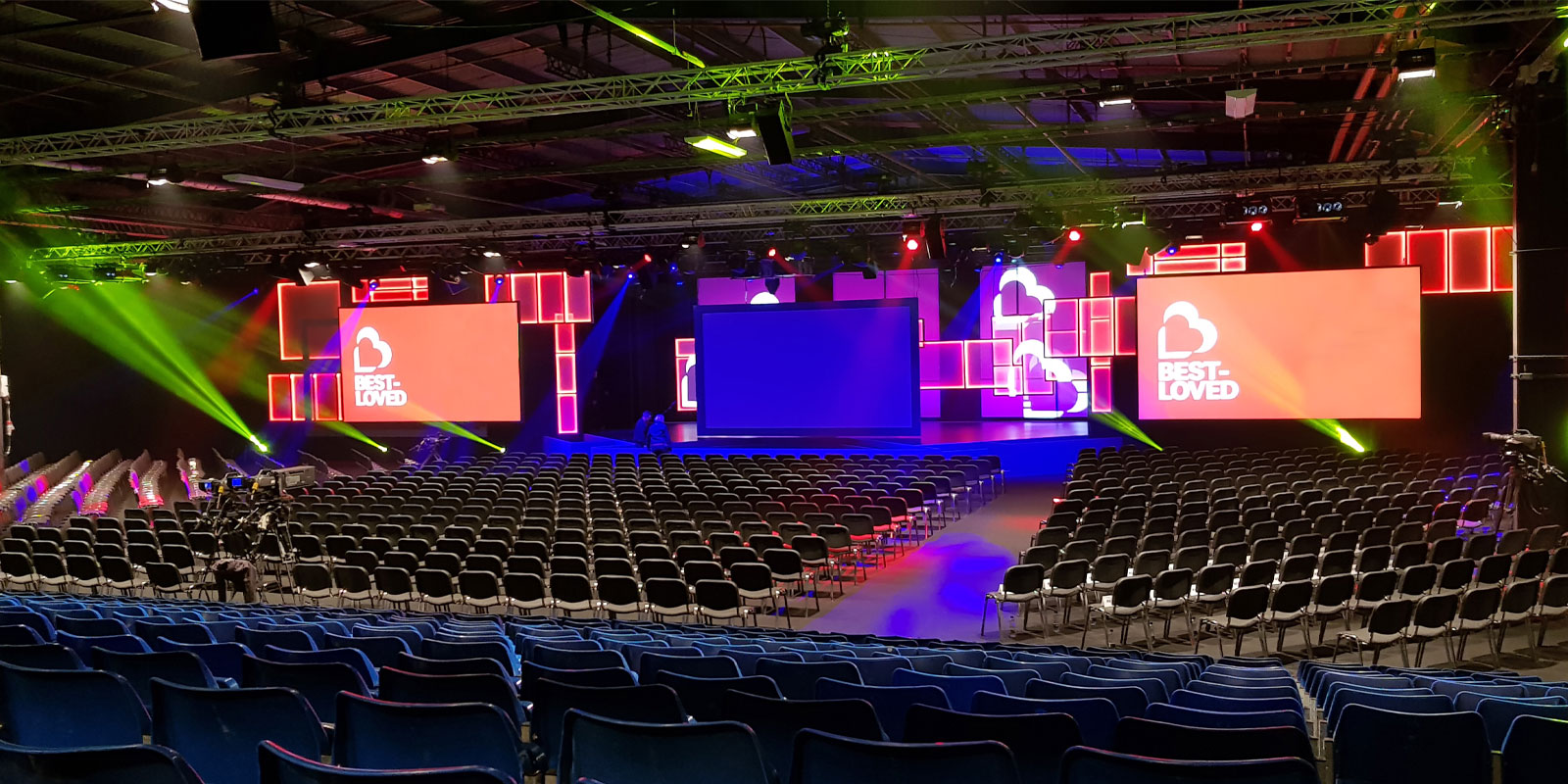 Hall 4 at EventCity: spacious theater-style conference setup with vibrant lighting. - Banner