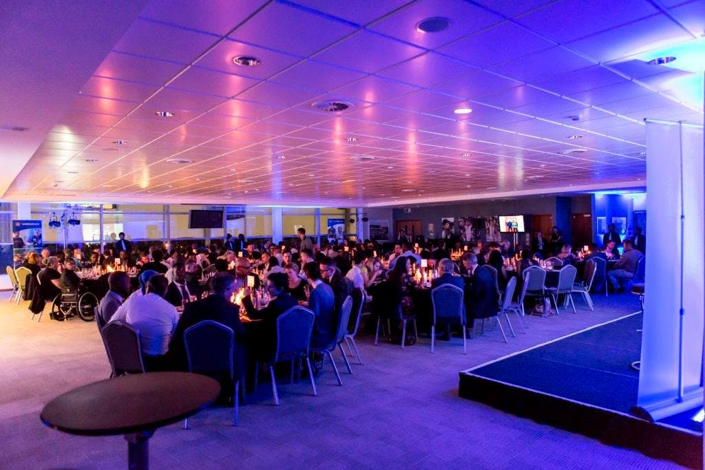 Elegant gala in Ashes Suite, Kia Oval with ambient lighting and networking focus.
