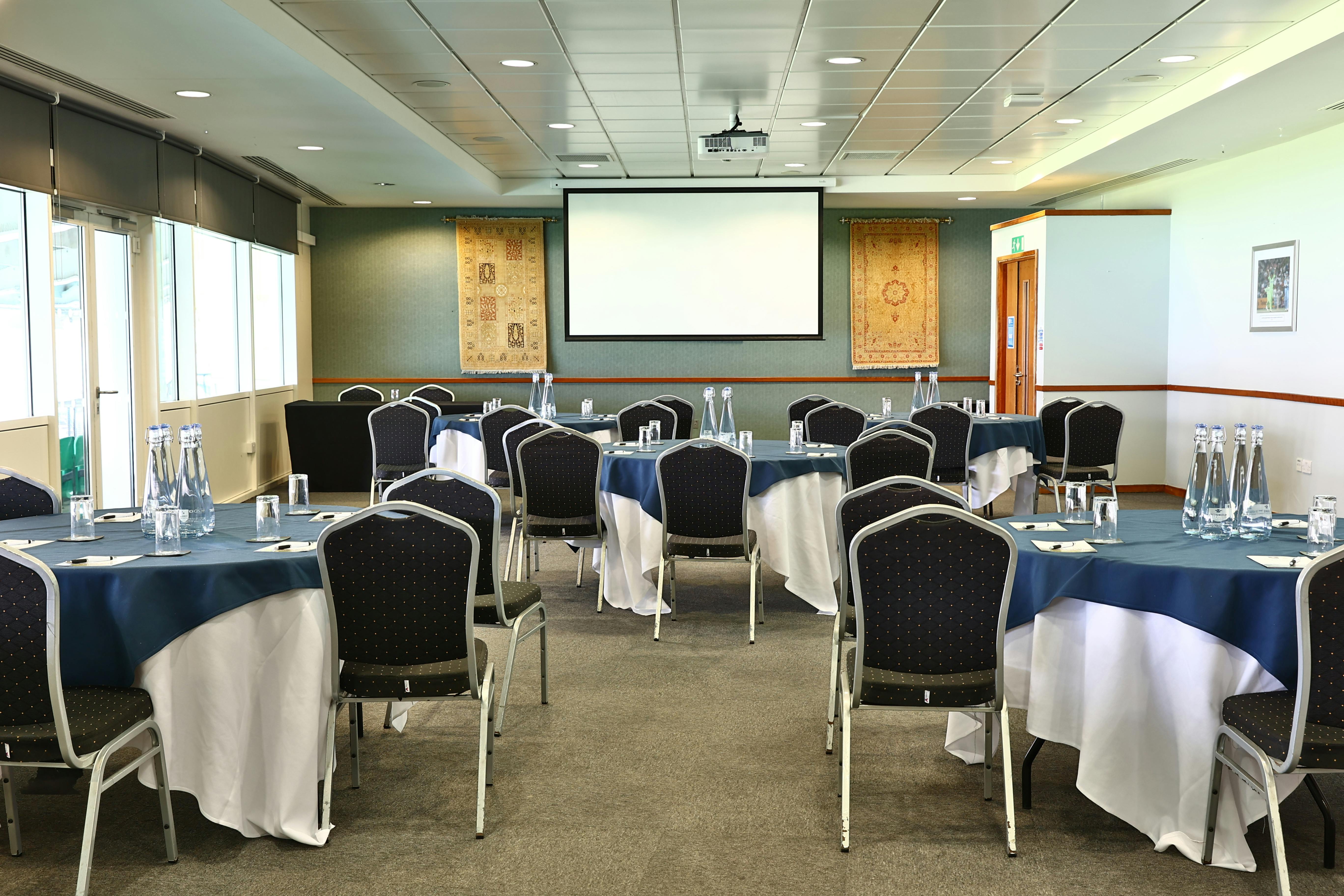 Kia Oval Pakistan Room: elegant meeting setup with blue linens for corporate events.