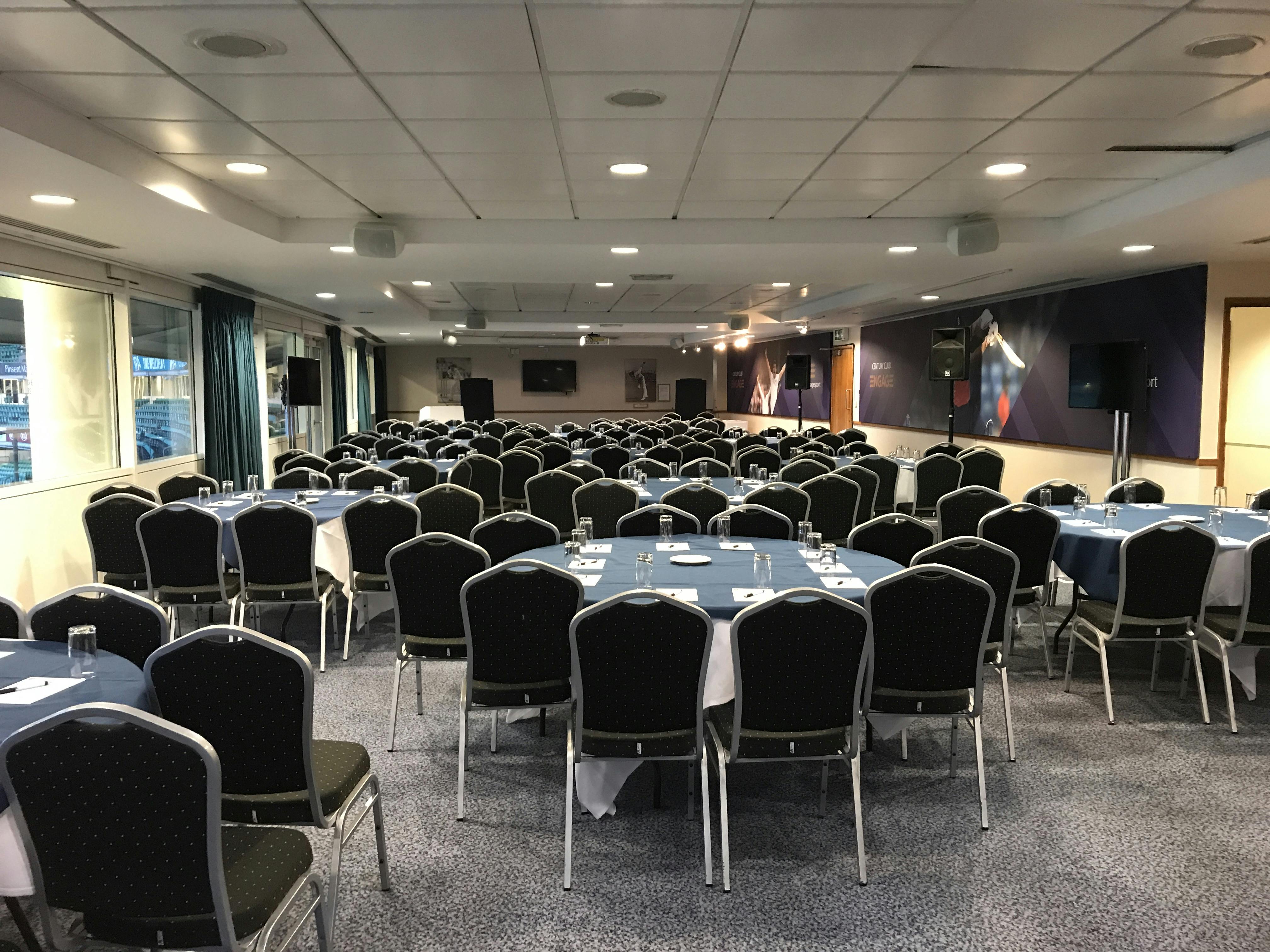 John Major Room at Kia Oval, set for a conference with blue tablecloths and AV equipment.