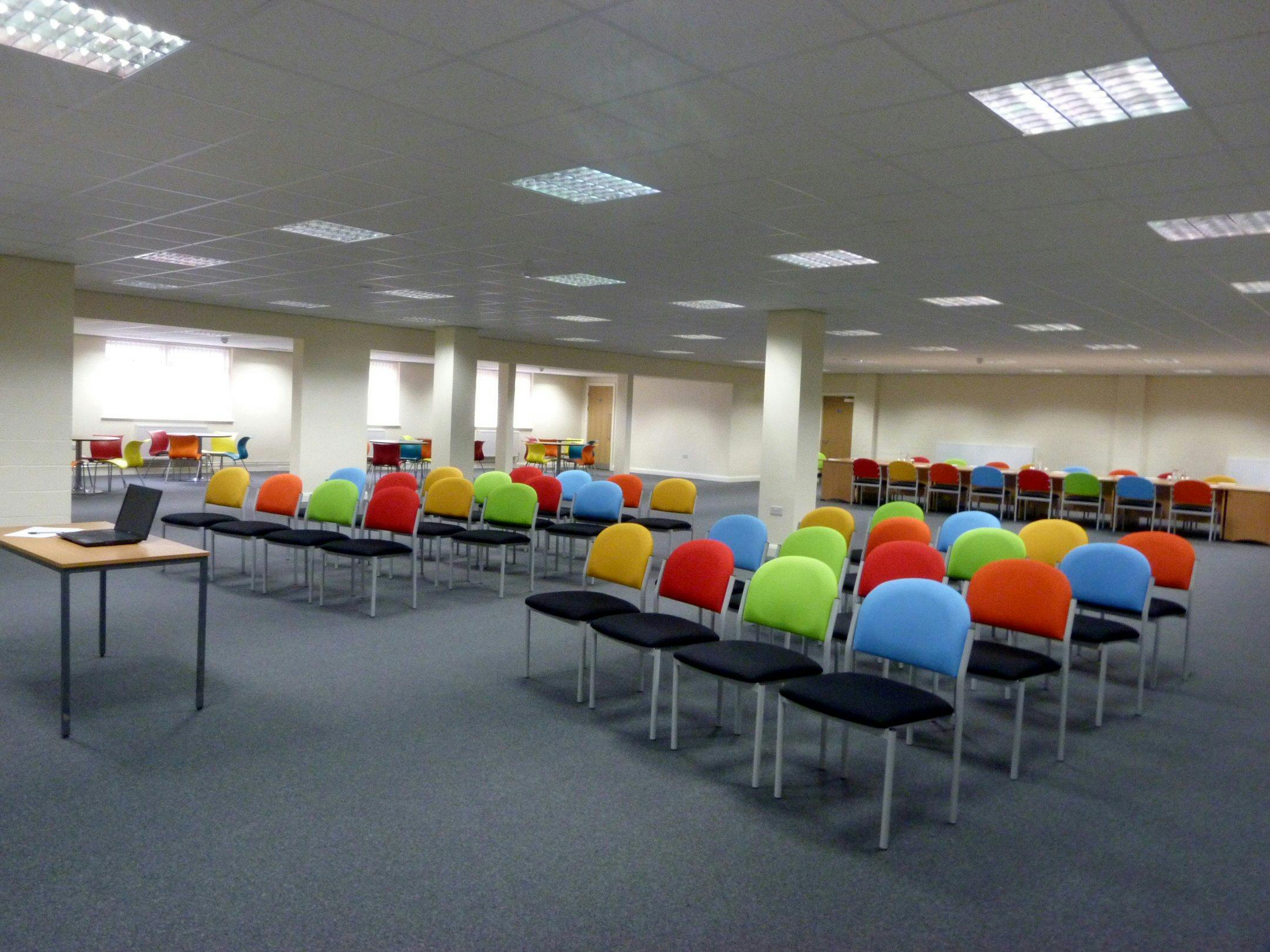 Versatile training room with colorful chairs for workshops and brainstorming sessions.