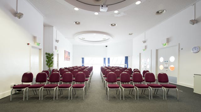 Hexagon Room at The Lowry with maroon chairs, perfect for conferences and workshops.