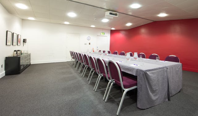 Meeting room in The Lowry with red accent wall, ideal for workshops and board meetings.