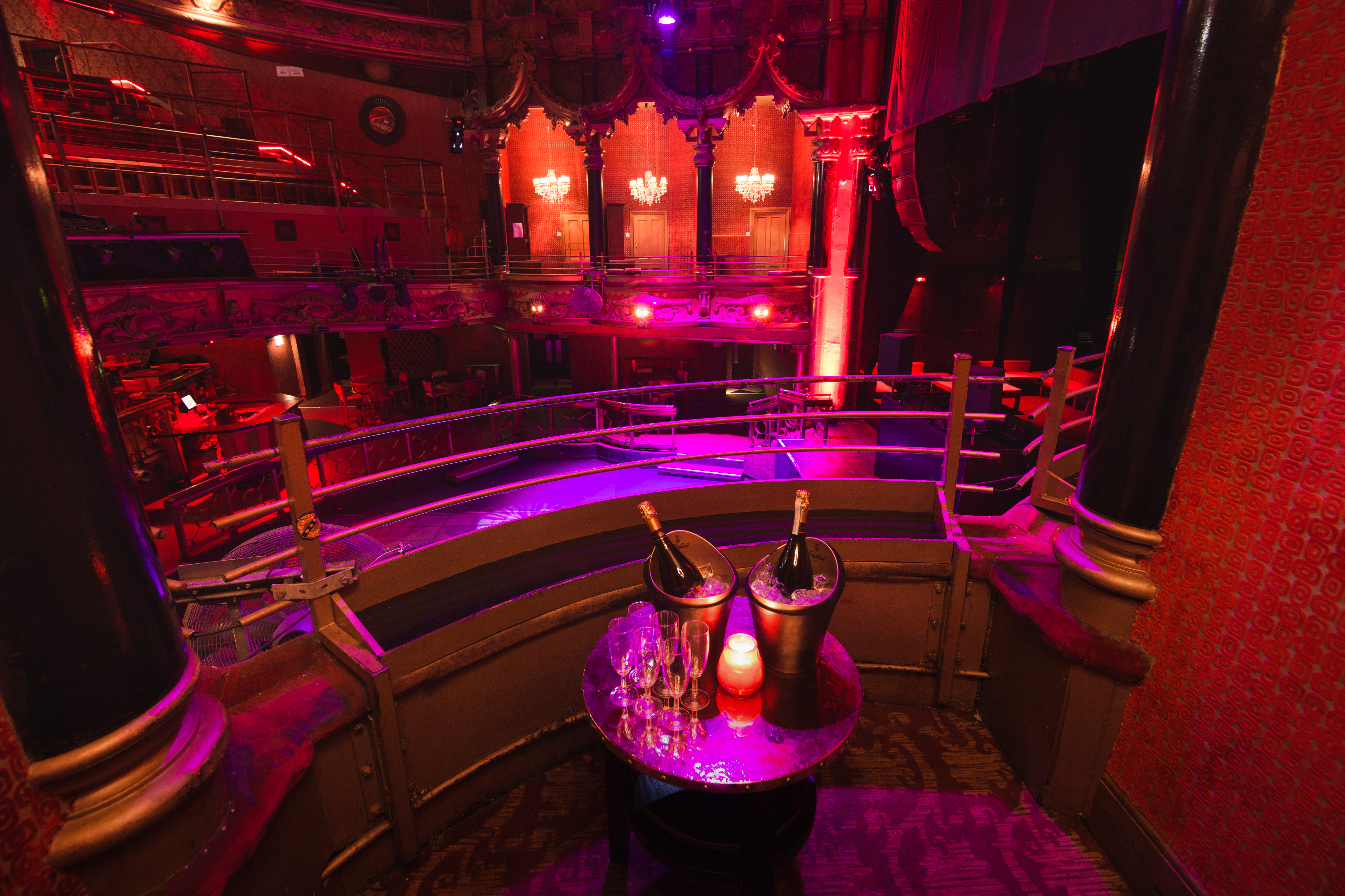Elegant event space in The Grand with stage, ambient lighting, and champagne for celebrations. - Banner