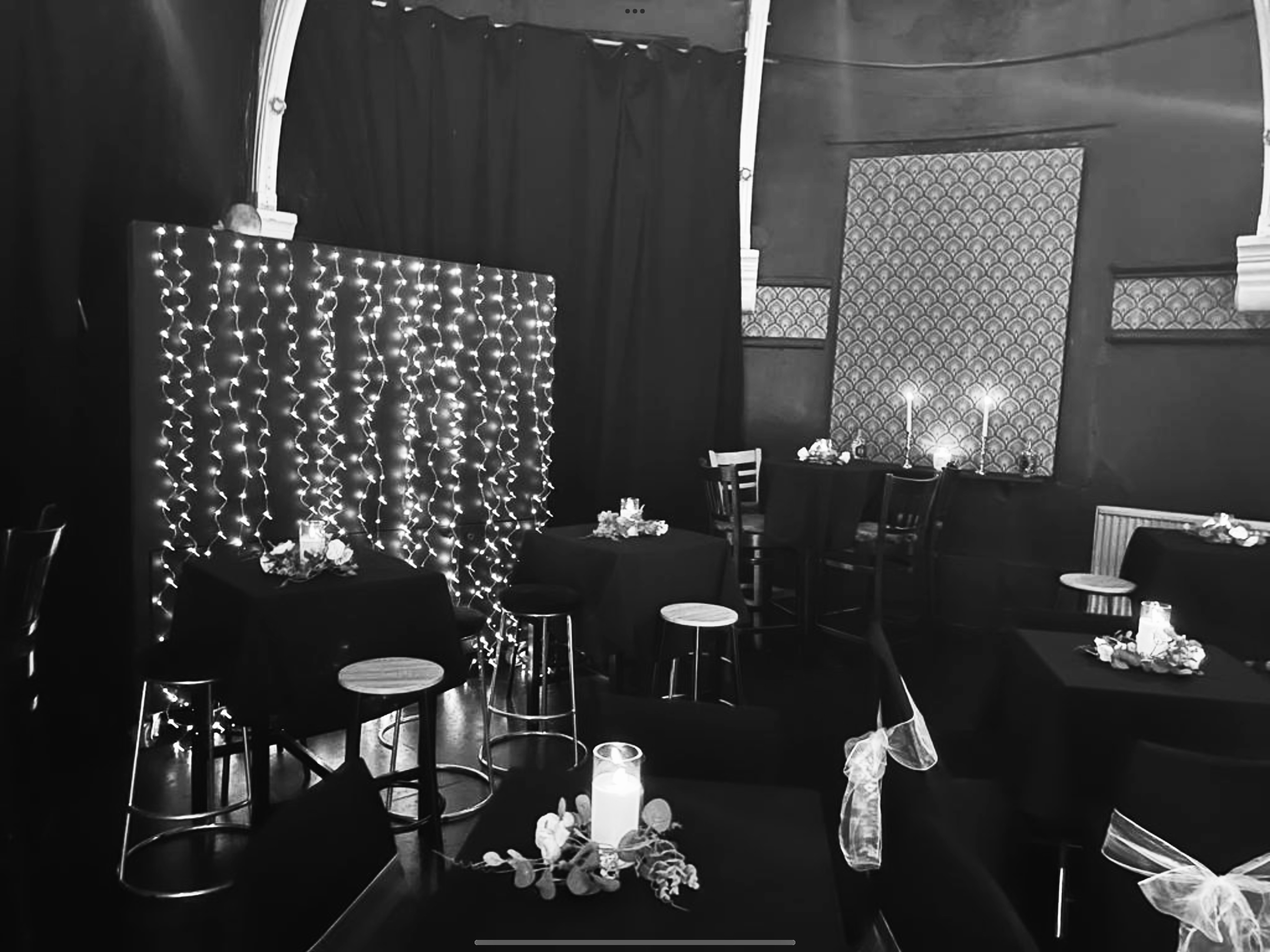 Elegant event space at Kings Arms Theatre with black tables and fairy lights. - Banner