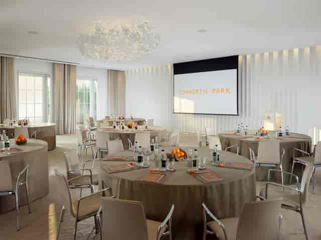 Oval Room at Coworth Park with round tables, ideal for corporate meetings and events.